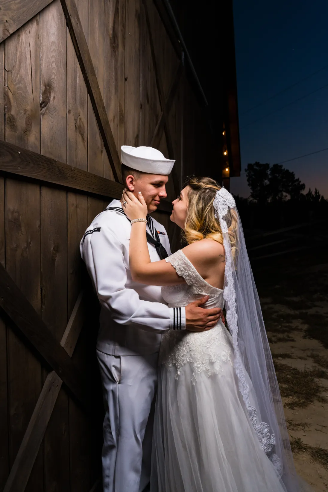sailor husband and bride against shiplap door weddings unlimited