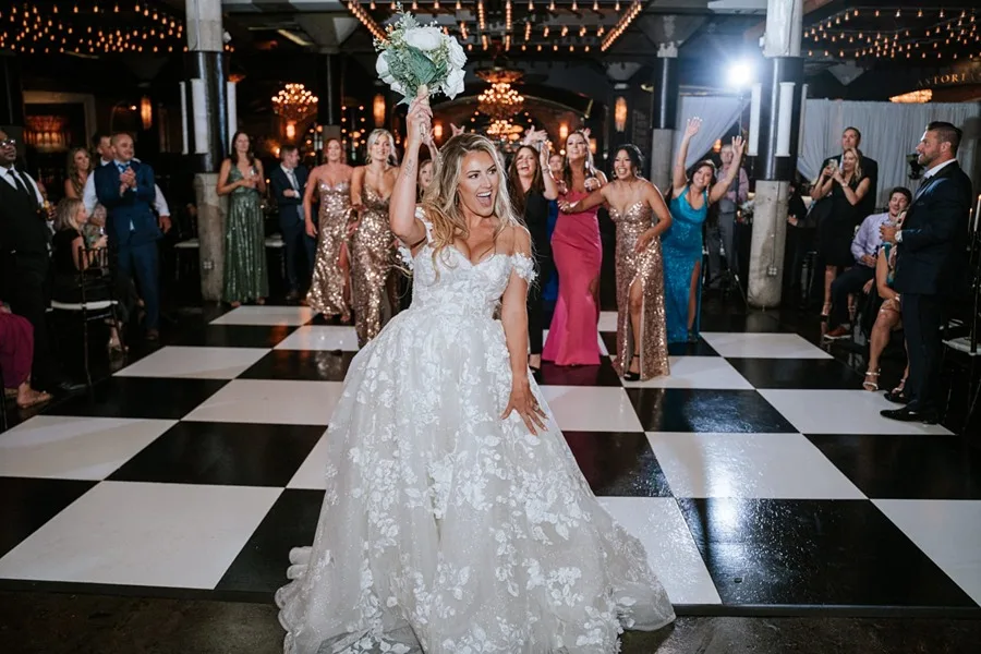 Houston Wedding Reception Bundle Bride tossing bouquet on black and white checkered dance floor during a Houston wedding reception
